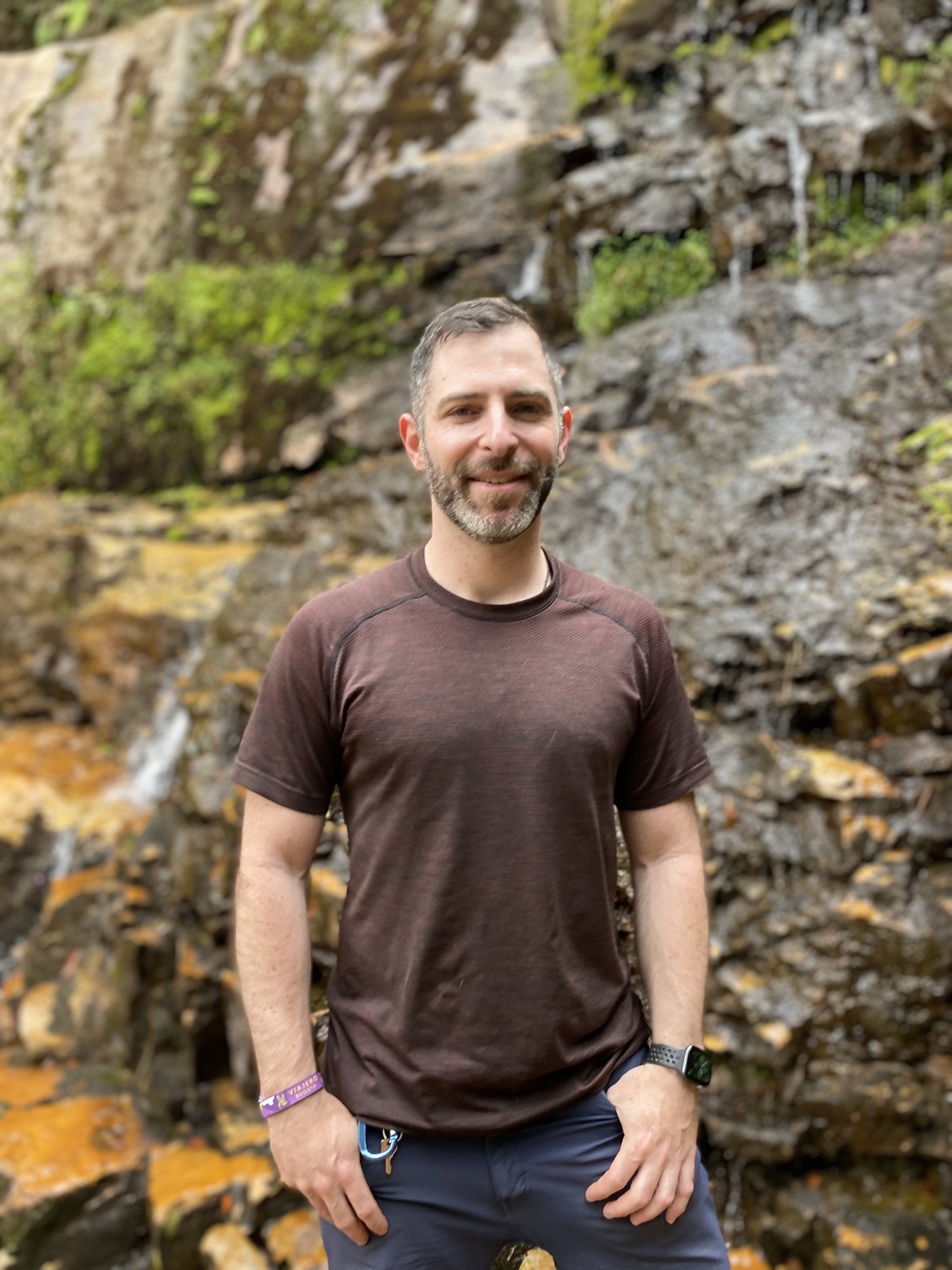 A man standing in front of a waterfall, grounded and present